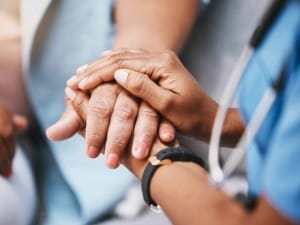 a picture of a healthcare worker holding hands with a patient.