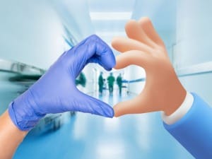 A picture of hands making a heart sign within a healthcare setting.