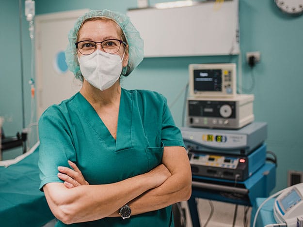 a picture of a NHS clinician stood in a hospital setting.