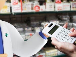 A picture of a pharmacy character using our healthcare benefits calculator in a pharmacy setting.